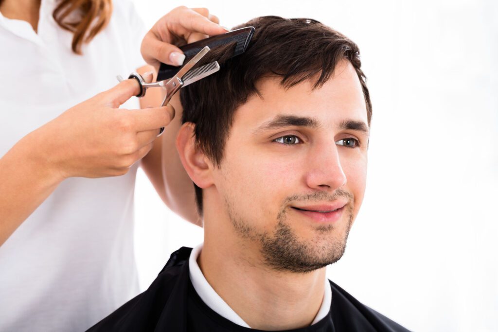 Happy Young Man Getting Haircut From Hairdresser