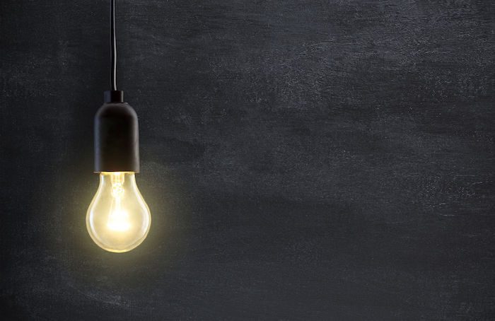 Light bulb lamp on blackboard background with copy space